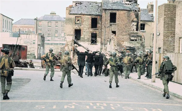  ??  ?? Arrested civilians are marched towards detention in the Bogside area of Londonderr­y by British troops on January 30 1972, which became known as Bloody Sunday