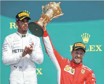  ?? FOTO: DPA ?? Beifall aus der zweiten Reihe: Lewis Hamilton (li.) haderte kräftig nach Sebastian Vettels Sieg.