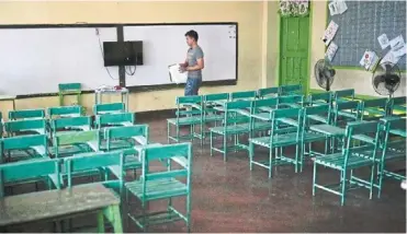  ?? ?? (Far left) a teacher arranges papers at an empty classroom at the Justo Lukban elementary school in Manila.