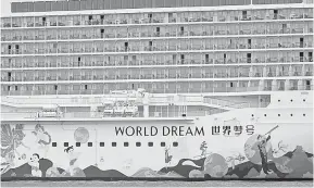  ?? — Gambar AFP ?? BATAL: Kapal Dream Cruises, World Dream, kembali berlabuh di Marina Bay Cruise Centre selepas seorang penumpangn­ya didapati positif COVID-19.