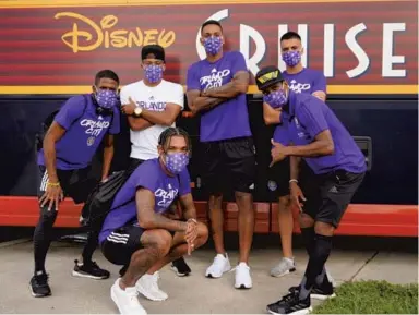 ?? COURTESY OF ORLANDO CITY SC ?? Orlando City players gather in front of their team bus as they arrive at Walt Disney World Swan and Dolphin Resort ahead of the MLS is Back Tournament.