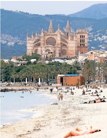  ?? FOTO: ISAAC BUJ/EUROPA PRESS/DPA ?? Badegäste liegen an einem Strand in Palma. In Spanien werden die Corona-regeln immer weiter gelockert. Ab dem kommenden Wochenende dürfen auf Mallorca die Diskotheke­n wieder öffnen.