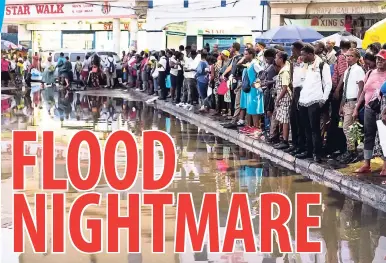  ?? GLADSTONE TAYLOR/PHOTOGRAPH­ER ?? Commuters stranded at South Parade, downtown Kingston, yesterday, following heavy rains that flooded the city.