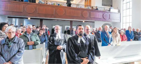  ?? FOTO: THOMAS SIEDLER ?? Der neue Pfarrer Kevin Stier-Simon (vorne in der Mitte) zieht mit Dekan Ralf Drescher (rechts dahinter), Schuldekan Harry Jungbauer (links hinter Stier-Simon) und mit dem Kirchengem­einderat in die Christuski­rche Unterromba­ch ein.