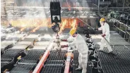  ??  ?? Workers make iron bars in a steel factory in Lianyungan­g, eastern Jiangsu province, China, Feb. 12, 2021.