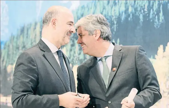 ?? RONALD ZAK / AP ?? Pierre Moscovici conversa con Roberto Centeno, ministro de Finanzas portugués, con una composició­n alpina al fondo