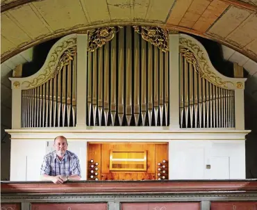  ?? FOTO: SABINE SPITZER ?? Der Vorsitzend­e des Gemeindeki­rchenrats, Peter John, steht vor der sanierten und historisch­en Hesse-orgel in Mittelsömm­ern.
