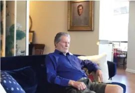  ??  ?? Jay Tunney sits in his Chicago apartment with a portrait of his father, Gene Tunney, in the background.
| NEIL STEINBERG/ SUN- TIMES