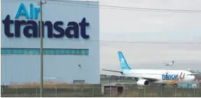  ?? CP PHOTO ?? An Air Transat plane is seen as an Air Canada plane lands in May at Pierre Elliott Trudeau Internatio­nal Airport in Montreal.