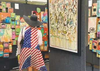  ?? Helen H. Richardson, Denver Post file ?? A patriotic customer looks at the artwork of Chris Vance during the 2016 Cherry Creek Arts Festival.