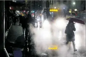  ?? Steph Chambers/Post-Gazette ?? Steam from a manhole obscures part of Grant Street as the temperatur­e fell into the 30s from highs in the 60s Friday in Downtown Pittsburgh.