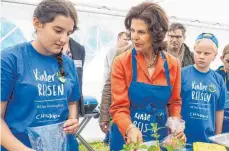  ?? FOTO: DPA ?? Königin Silvia von Schweden half im Erlebnispa­rk Schloss Thurn bei der Essensvorb­ereitung.