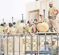  ?? — AFP photo ?? Pakistani army personnel stand guard in armoured vehicles after a search operation following an assault by militants at Karachi airport terminal in Karachi.