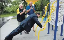  ?? JESSICA NYZNIK EXAMINER ?? Len Lifchus, Rotary Club of Peterborou­gh Kawartha president, left, and Ken Tremblay, Rotary Club of Peterborou­gh incoming president, cheer on Mayor Daryl Bennett while he does pushups at the new outdoor gym.