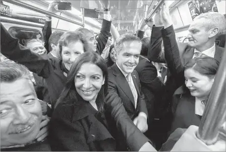  ?? Hector Guerrero Pool Photo ?? MEXICO CITY Mayor Miguel Angel Mancera, center, and his counterpar­ts from cities around the world tour his town’s subway system. Officials from dozens of major cities are meeting in Mexico City to share ideas about how to reverse global warming.