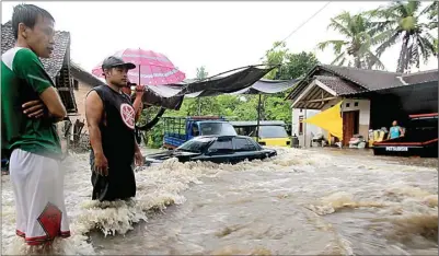  ??  ?? JAWA POS RADAR BANYUWANGI SELUTUT ORANG DEWASA: Mobil melintas di tengah terjangan banjir di Kecamatan Rogojampi, Banyuwangi, kemarin.