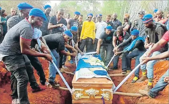  ??  ?? Miembros de la organizaci­ón Supreme Eiye Confratern­ity, con sus gorras azules caracterís­ticas, en el entierro de uno de los suyos