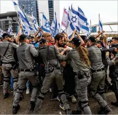  ?? OHAD ZWIGENBERG/AP ?? Israeli police scuffle with demonstrat­ors blocking a road Thursday in Tel Aviv, Israel, during a protest against plans by Prime Minister Benjamin Netanyahu’s government to overhaul the judicial system.