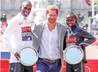  ?? NEIL HALL/EPA ?? SAMBUT JUARA: Pangeran Harry bersama juara London Marathon 2018 Eliud Kipchoge (kiri) dan Vivian Cheruiyot. Dua pelari tersebut berasal dari Kenya.