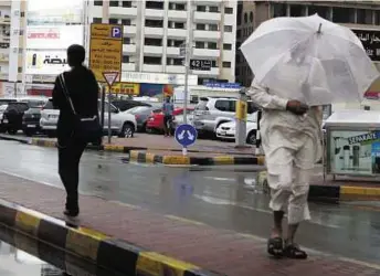  ??  ?? Braving the elements Many residents woke up to rain yesterday. Temperatur­es have dropped and people are advised to take care if venturing out in the wind and rain.
Atiq- Ur- Rehman/ Gulf News