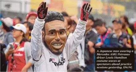  ?? EPA PIC ?? A Japanese man wearing a Mercedes AMG Petronas driver Lewis Hamilton costume waves at spectators ahead practice sessions yesterday.