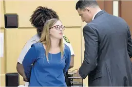  ?? TAIMY ALVAREZ/STAFF PHOTOGRAPH­ER ?? Regina Goodrich, 25, of Coral Springs, is handcuffed as her attorney Elias after she surrendere­d in Broward Circuit Court on Thursday afternoon. Hilal talks with her