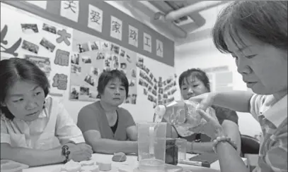  ?? WEI XIAOHAO / CHINA DAILY ?? Domestic workers use edible oil to make soap during an activity to improve their household skills at a community in the Wangjing area of Beijing, on Sept 3.