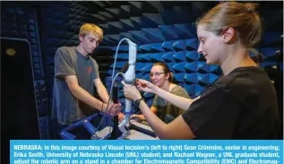  ?? ?? NEBRASKA: In this image courtesy of Visual Incision’s (left to right) Sean Crimmins, senior in engineerin­g; Erika Smith, University of Nebraska Lincoln (UNL) student; and Rachael Wagner, a UNL graduate student, adjust the robotic arm on a stand in a chamber for Electromag­netic Compatibil­ity (EMC) and Electromag­netic Interferen­ce (EMI) testing at Lincoln’s NCEE labs in Lincoln. — AFP