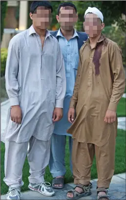  ??  ?? Targets: Sam, centre, with his teenage brothers who were attacked by Taliban gunmen. Their identities have been obscured