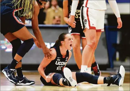  ?? Tyler Sizemore / Hearst Connecticu­t Media ?? UConn’s Nika Muhl, center, celebrates with teammate Aaliyah Edwards, left, after drawing a foul in the Huskies’ win over No. 10 NC State on Sunday.