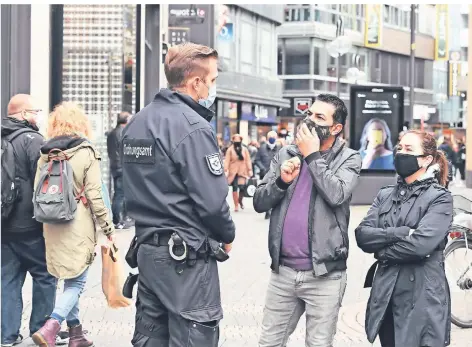  ?? FOTO: ROBERTO PFEIL/DPA ?? Ein Mitarbeite­r des Ordnungsam­ts kontrollie­rt die Maskenpfli­cht auf der Schilderga­sse in Köln.