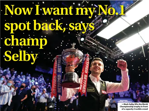  ??  ?? > Mark Selby lifts the World Championsh­ip trophy in front of a capacity Crucible crowd