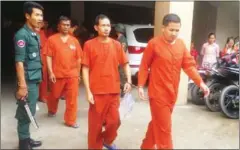  ?? SUPPLIED ?? Ngun Satya (second from right), who was arrested last year for pretending to be a two-star general, is escorted by officials after his hearing yesterday at the Phnom Penh Municipal Court.