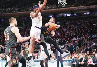  ?? (AP) ?? Atlanta Hawks guard Allen Crabbe (33) attempts to pass to Hawks center Alex Len (25) getting around the defense of New York Knicks center Mitchell Robinson (23) during the first half of an NBA basketball game in New York on
Dec 17.