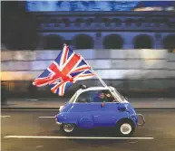  ?? DANIEL LEAL-OLIVAS / AFP VIA GETTY IMAGES ?? A man waves Union flags from a BMW Isetta on Jan. 31,
the day the U.K. formally left the European Union.