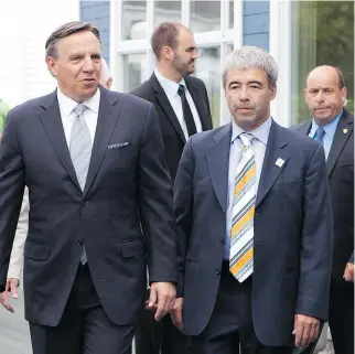  ?? JACQUES BOISSINOT/ THE CANADIAN PRESS ?? Coalition Avenir Quebec Leader Francois Legault, left, seen here with candidate Stéphane Le Bouyonnec, has accused Liberals of trying to discredit the ethics commission­er.