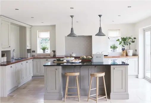  ??  ?? Kitchen Shaker cabinets painted in soothing neutrals are topped in granite and wood.
Cabinets, made to Rob’s design by Redbrook Kitchens; painted in Stony Ground and (island) Mouse’s Back, both by Farrow & Ball.
Bar stools, Cox & Cox....