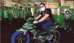  ?? (Foto BERNAMA) ?? Wan Ahmad Fayhsal mencuba motosikal milik pelumba ONEXOX TKKR SAG Team, Md Faiz Zekri Sabri ketika membuat lawatan sempena hari pertama perlumbaan Cub Prix di SIC, semalam.