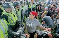  ?? AP ?? A protester confronts riot gear-clad police on the campus of the University of Virginia during a rally to mark the anniversar­y of last year’s Unite the Right rally in Charlottes­ville. —