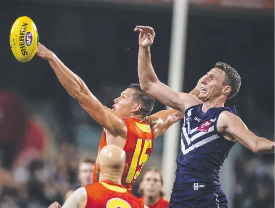  ?? Picture: AAP IMAGE ?? Daniel Currie goes up against Fremantle rival Jonathon Griffin during the Suns loss at Domain Stadium on Saturday night.