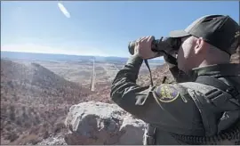  ?? Brian van der Brug Los Angeles Times ?? A BORDER PATROL agent surveys the border from Jacumba Hot Springs, Calif., last month, when crossings increased dramatical­ly compared with March 2017.