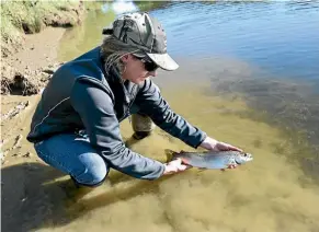  ??  ?? Field Officer Erin Garrick with a Brown Trout, perfect for the microwave! PHOTO: SUPPLIED