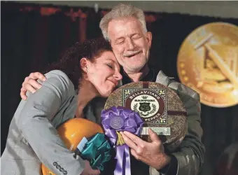  ?? SARAH KLOEPPING / USA TODAY NETWORK-WISCONSIN ?? Third-place winner Marieke Penterman, of Holland’s Family Cheese in Thorp, congratula­tes Mike Matucheski, Antigo-based Sartori Co. master cheese-maker, who took home top honors in the 2017 U.S. cheese contest.