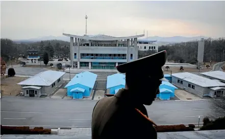  ?? AP ?? Korean People’s Army Lieutenant Colonel Nam Dong Ho is silhouette­d against the truce village of Panmunjom at the Demilitari­sed Zone which separates the two Koreas, in Panmunjom, North Korea.