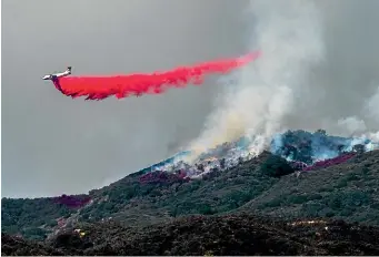  ?? AP ?? A plane drops fire retardant as firefighte­rs continue to battle a wildfire in the Cleveland National Forest near Corona, California, yesterday. Firefighte­rs have struggled against rugged terrain, high winds and an August heat wave to slow the spread of the biggest wildfire ever recorded in California, an inferno that exploded to be nearly the size of Los Angeles in just 11 days. The 1,165-square-kilometre blaze, centred near the community of Upper Lake, about 160km north of San Francisco, spread fast because of what officials said was a perfect combinatio­n of weather, topography and abundant vegetation turned into highly flammable fuel by years of drought.