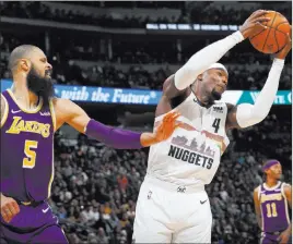  ?? David Zalubowski ?? The Associated Press Nuggets forward Paul Millsap pulls down a rebound in front of Lakers center Tyson Chandler during Denver’s 117-85 home victory Tuesday.