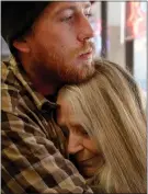  ??  ?? Camp Fire evacuee Morgan Randall comforts his Magalia neighbor Liz Edwards, 68, at her shelter inside Azad’s Martial Arts Center in Chico on Tuesday.