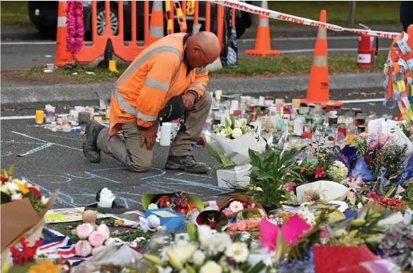  ?? Photo: AAP/MICK TSIKAS ?? TERROR: A worker grieves at a memorial at the Al Noor Mosque in Christchur­ch, New Zealand. A gunman killed 50 worshipper­s at the Al Noor Masjid and Linwood Masjid. A 28-year-old Australian man, Brenton Tarrant, has been charged with murder.