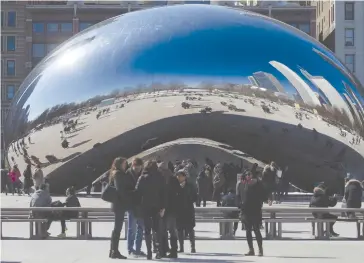  ?? (Carlo Allegri/Reuters) ?? PEOPLE POSE for photos at the Cloud Gate public sculpture on a sunny day in Millennium Park in Chicago on Thursday.