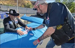  ?? Gilbert Bernal/The Signal ?? Alan Ferdman, president of Elks Riders Lodge 2379, deals the cards for Michael “Cowboy” Couch who road form Las Vegas to participat­e in the third annual Toy Run for Veterans Children fundraiser held at the Elks Lodge in Canyon Country on Saturday.